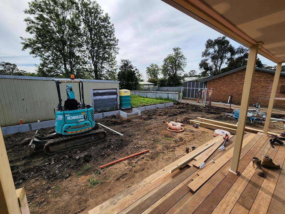 A View Of A Backyard Building Wooden Deck With Construction Equipment — Entire Trades in Port Stephens, NSW