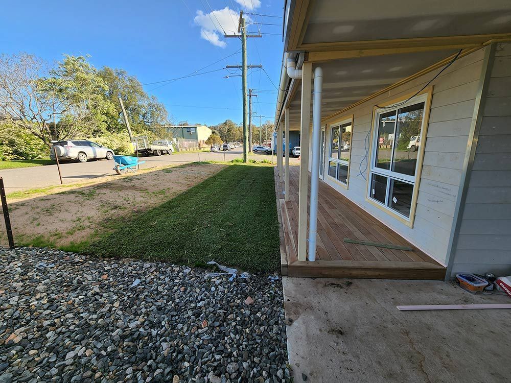 A House With A Wooden Deck And A Lot Of Windows Is Being Built — Entire Trades in Central Coast, NSW