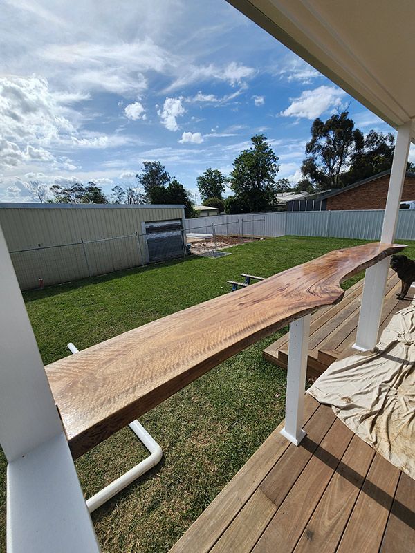A Wooden Bench Positioned On A Deck, Surrounded By A Landscape Outdoor Setting — Entire Trades in Cessnock, NSW