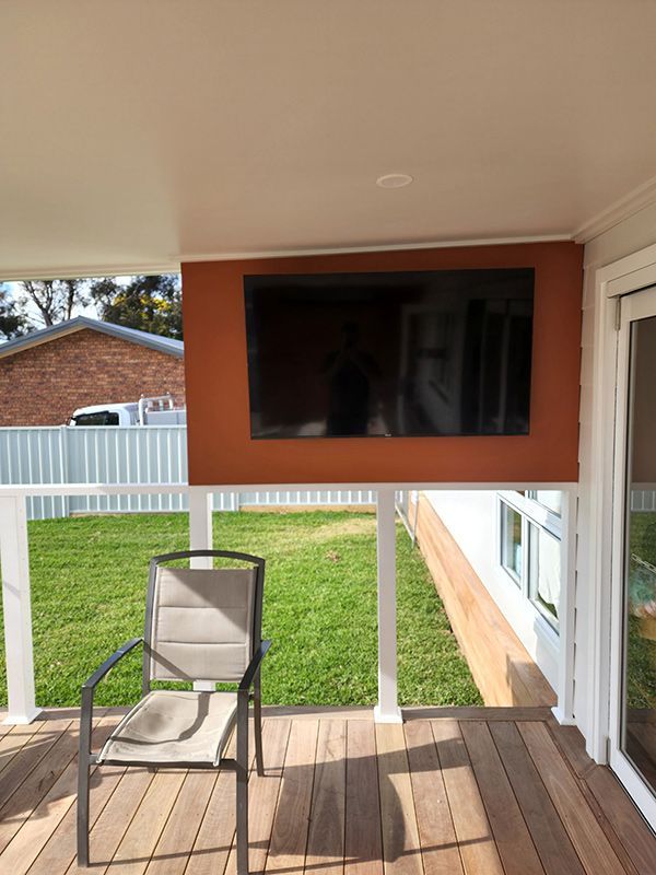 A TV Mounted On A Wall In A Deck Setting — Entire Trades in Port Stephens, NSW