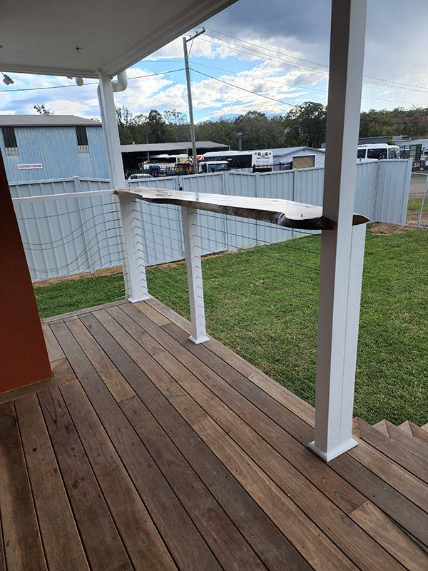 A Wooden Deck With A White Railing And A Fence In The Background — Entire Trades in Central Coast, NSW