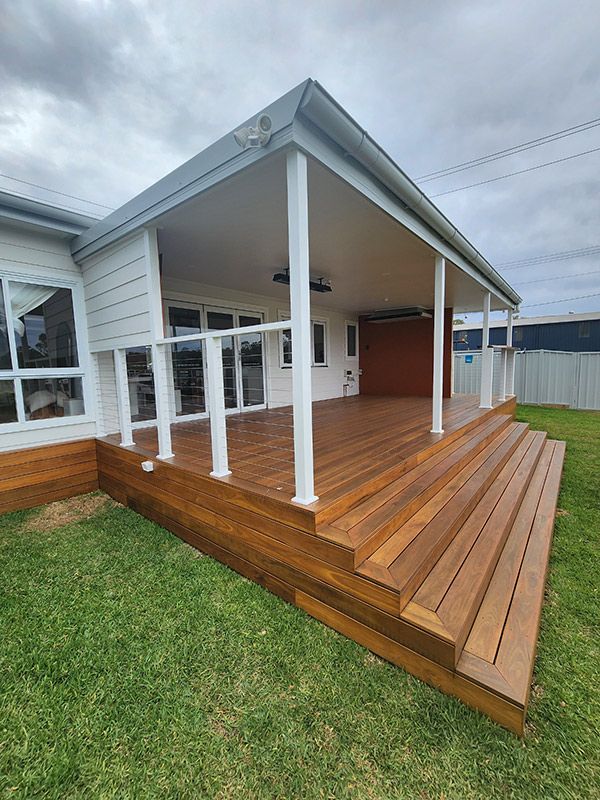 A House With A Wooden Deck And Stairs In Front — Entire Trades in Maitland, NSW