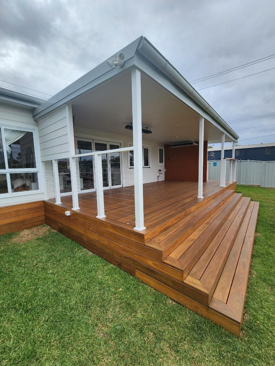 A Large Wooden Deck with Stairs Is in Front of A House — Entire Trades in Maitland, NSW