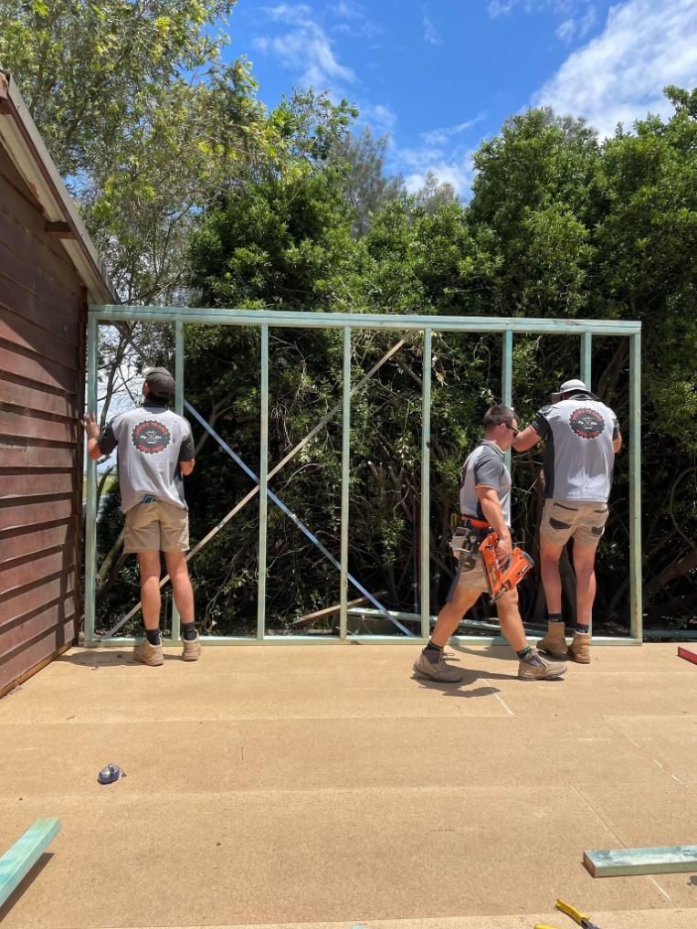 A Group of Construction Workers Are Working on A Building — Entire Trades in Maitland, NSW