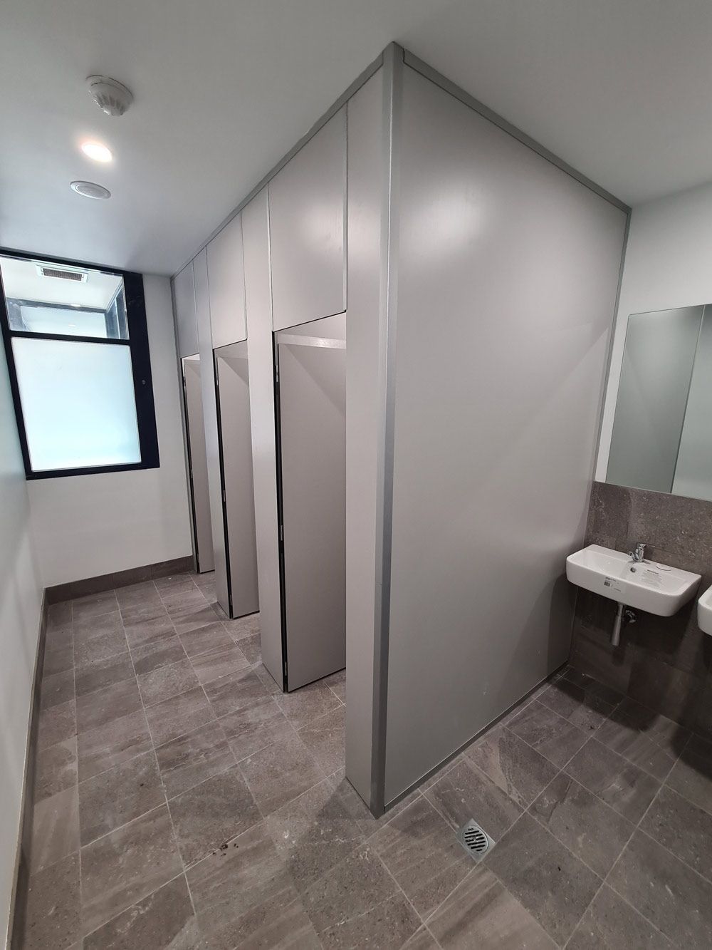 A Bathroom With A Sink, Toilets And A Mirror With Open Lights — Entire Trades in Central Coast, NSW