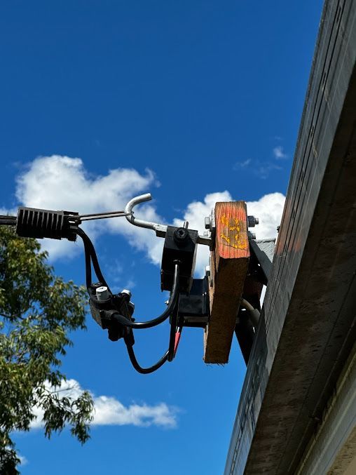 A Piece Of Wood Is Attached To The Side Of A Building With Electrical Cable Installed — Entire Trades in Singleton, NSW