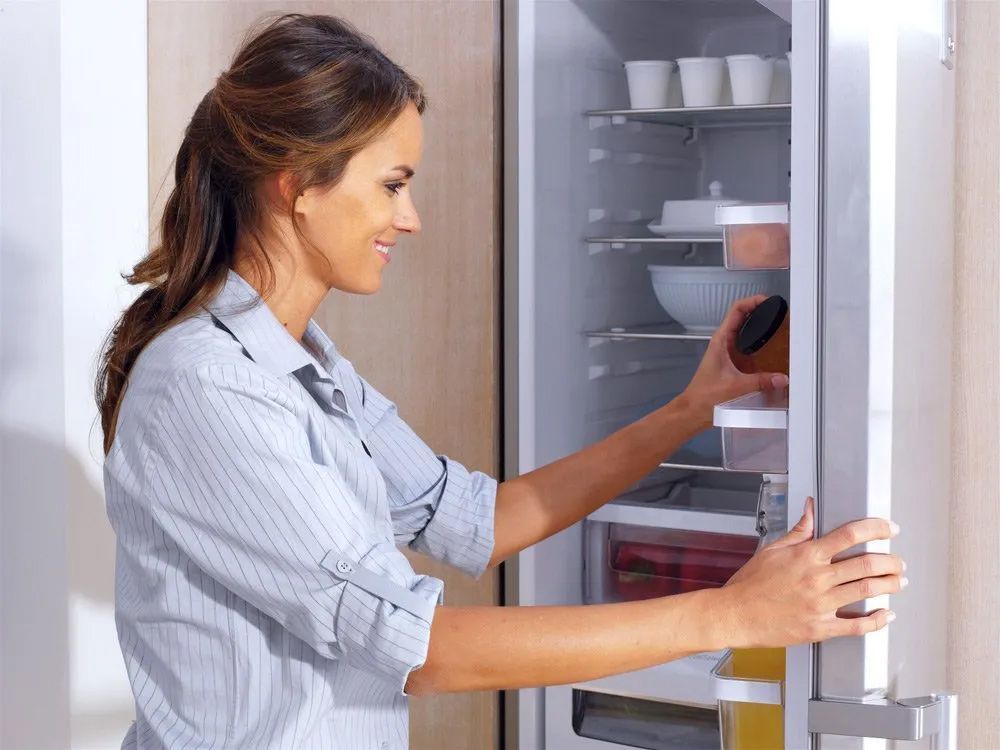 A Woman Is Taking Something Out Of A Refrigerator — Entire Trades in Maitland, NSW