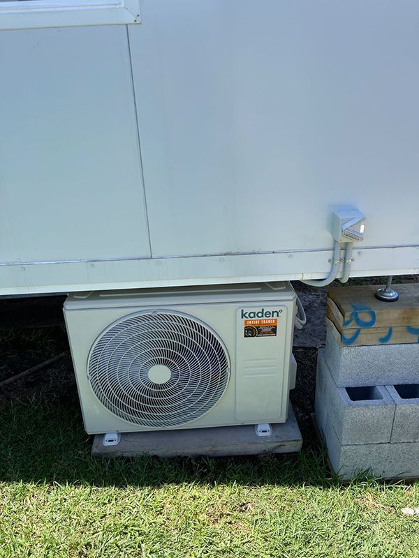 A Kaden Air Conditioner Is Sitting On The Ground Next — Entire Trades in Central Coast, NSW