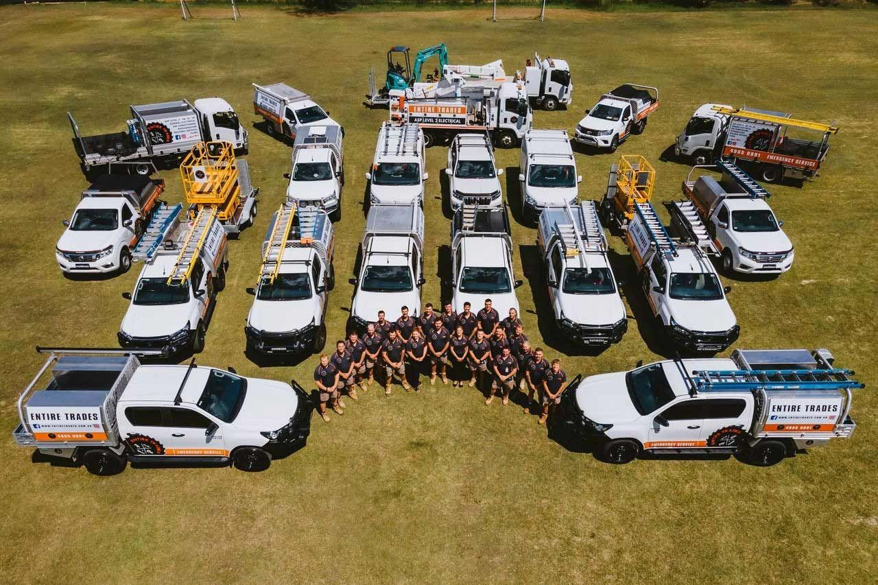 A Group Of Pickup Trucks Are Lined Up In A Row In A Field With Aerial View — Entire Trades in Maitland, NSW