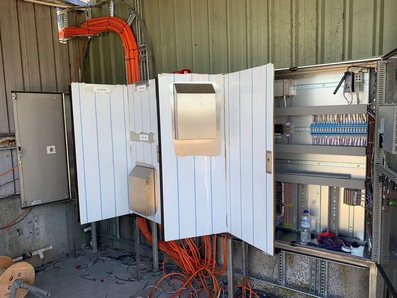 An Electrical Panel With A Door, Prominently Displaying Orange Wires — Entire Trades in Cessnock, NSW