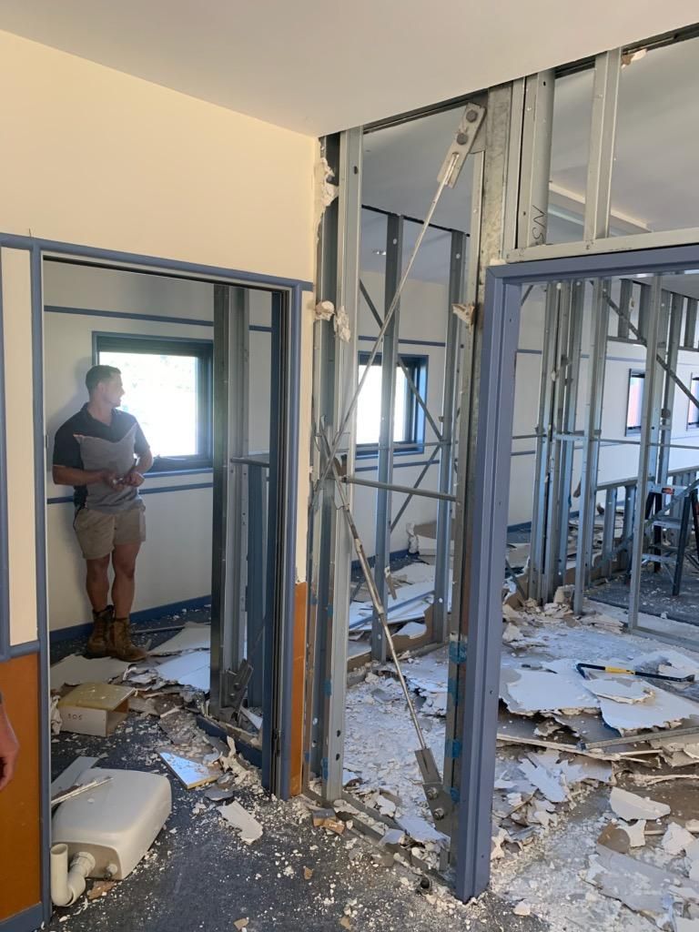 A Man Is Standing in A Room that Is Being Remodeled — Entire Trades in Maitland, NSW