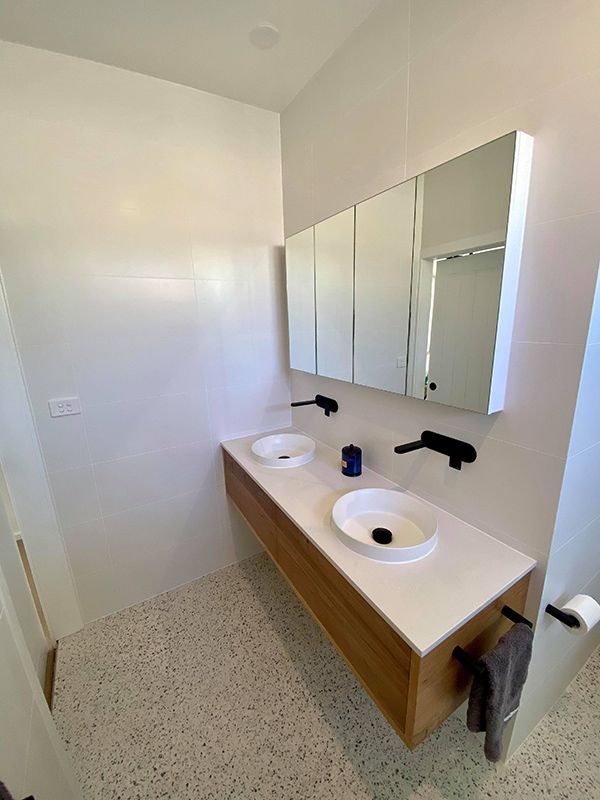 Beautiful And Modern Bathroom With Cabinets Mounted On Walls — Entire Trades in Central Coast, NSW