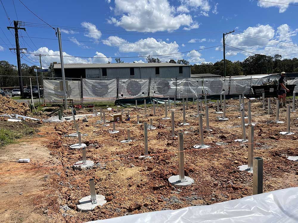 Construction Site With Multiple Poles And A Fence — Entire Trades in Cessnock, NSW