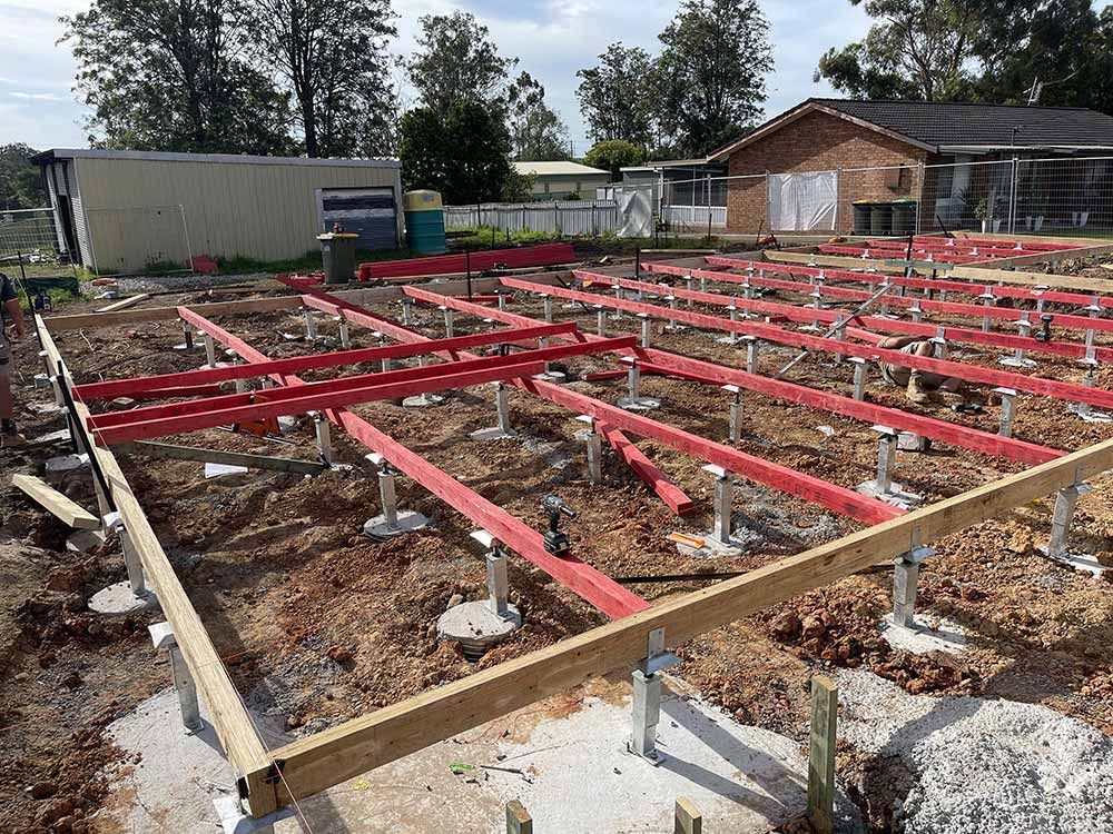 A House Under Construction With Steel Beams And Red Posts — Entire Trades in Port Stephens, NSW