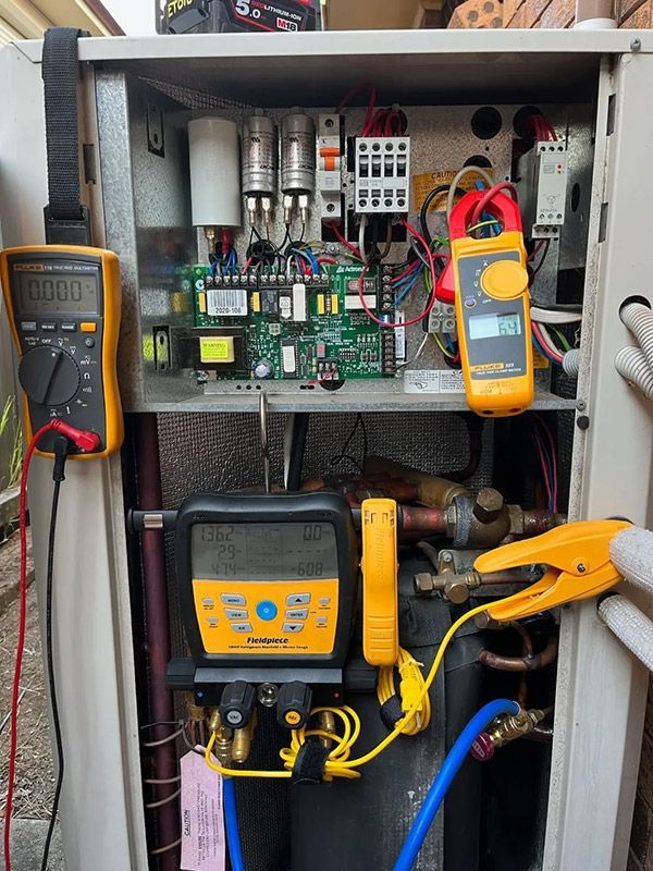 The Technician Worker Is Repairing An Air Conditioner With Three Multimeter — Entire Trades in Cessnock, NSW