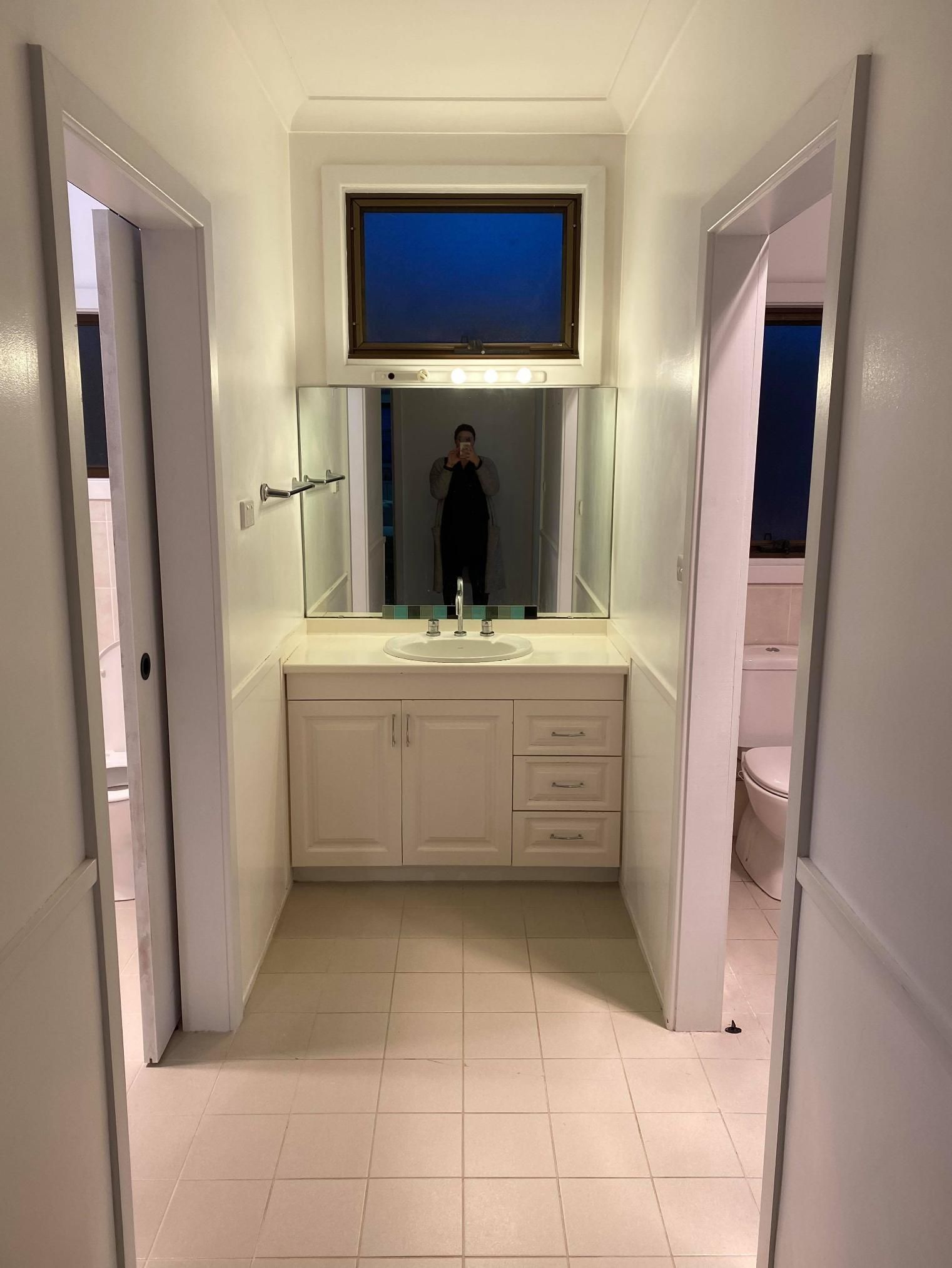 A Bathroom with A Sink, Mirror and Toilet — Entire Trades in Maitland, NSW