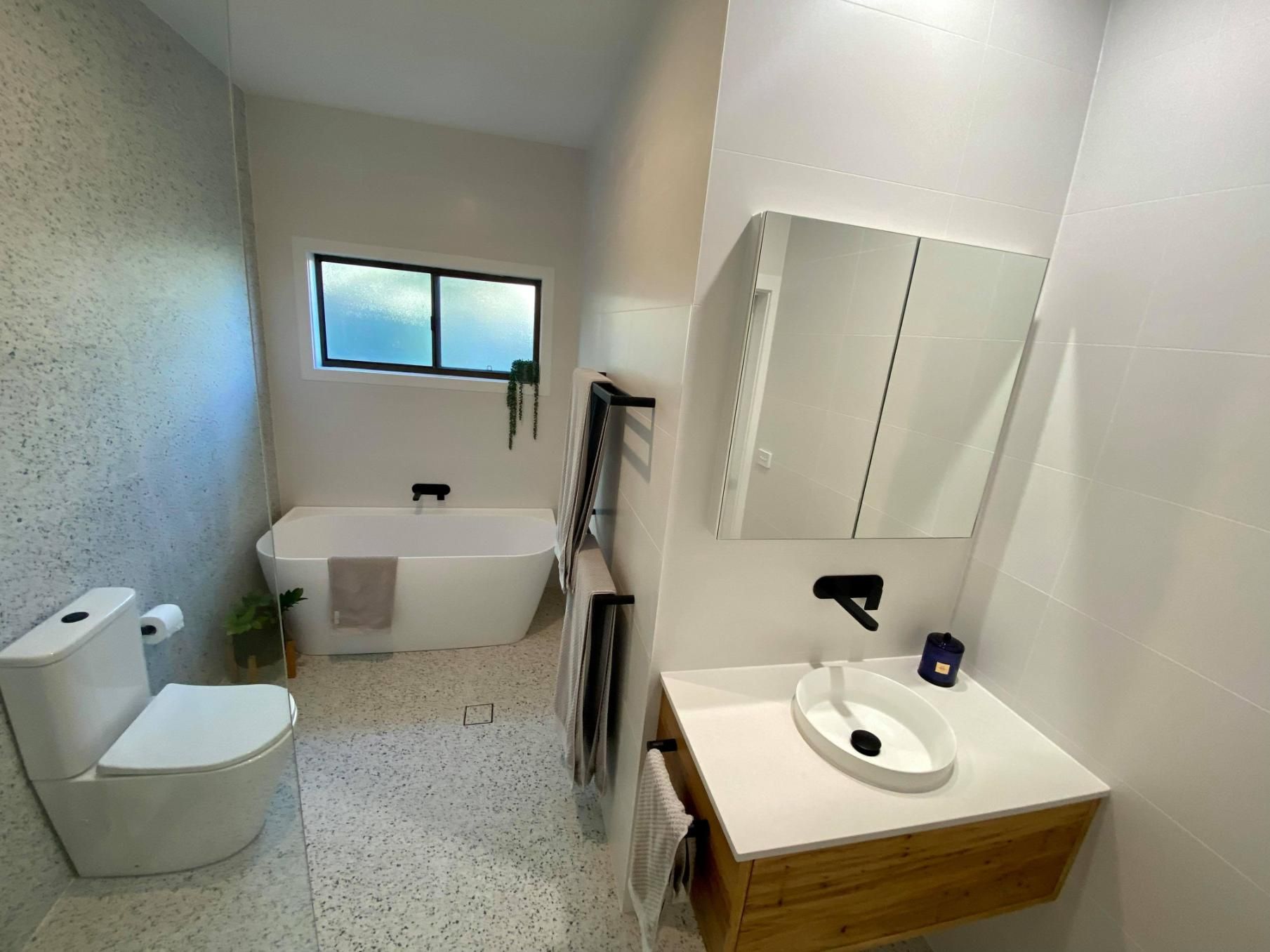 A Bathroom with A Tub, Toilet, Sink and Mirror — Entire Trades in Maitland, NSW