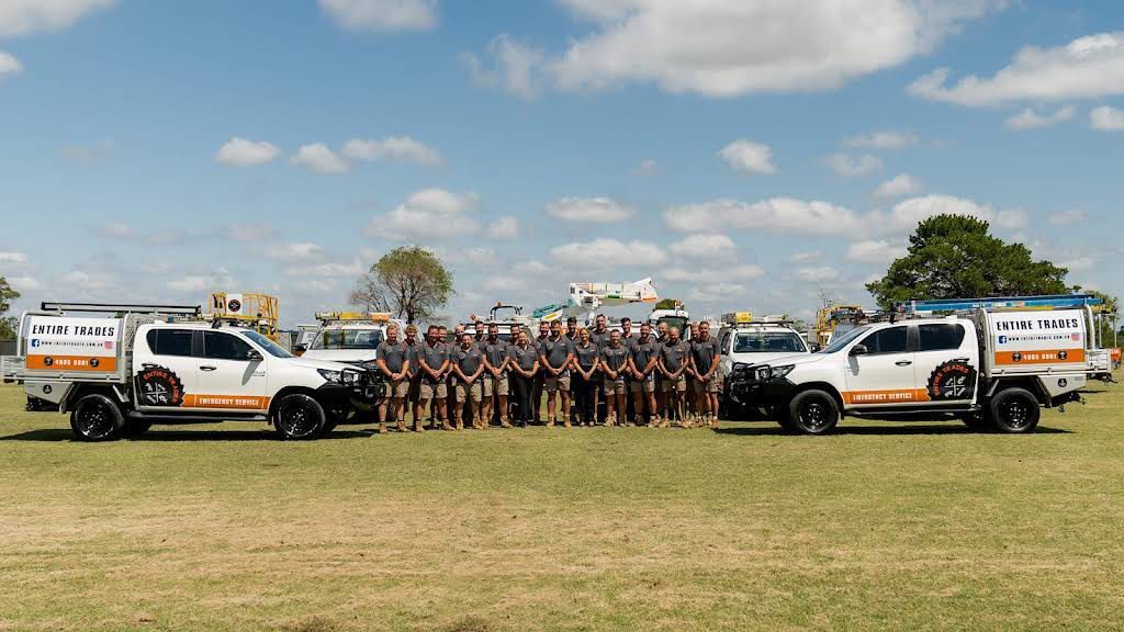 Electricians Standing in The Field with Vehicles