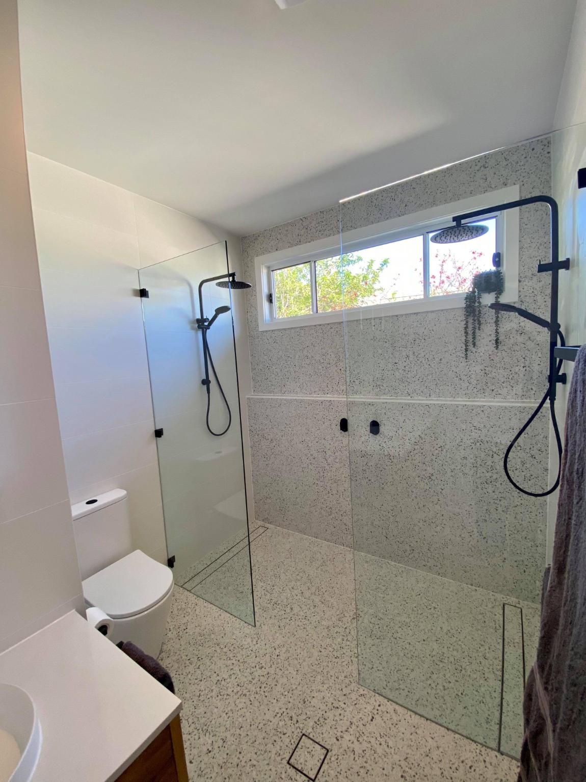 A Bathroom with A Toilet, Sink, Shower and Window — Entire Trades in Maitland, NSW