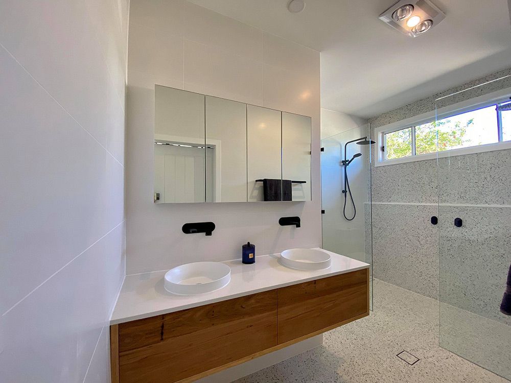A Bathroom With Two Sinks And A Walk In Shower And Lights — Entire Trades in Central Coast, NSW