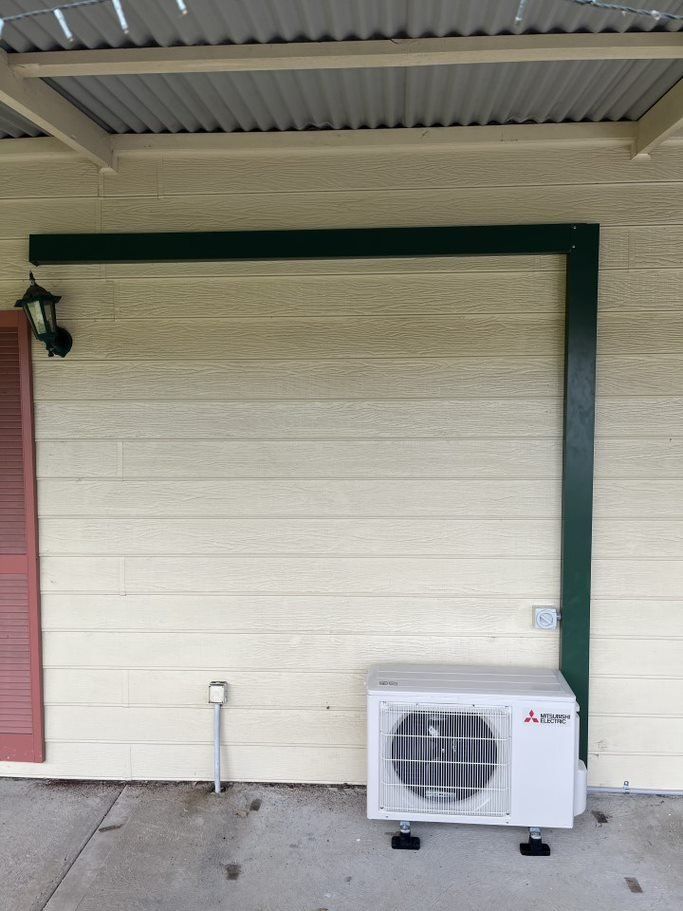 A Mitsubishi Air Conditioner Is Mounted on The Side of A House — Entire Trades in Maitland, NSW