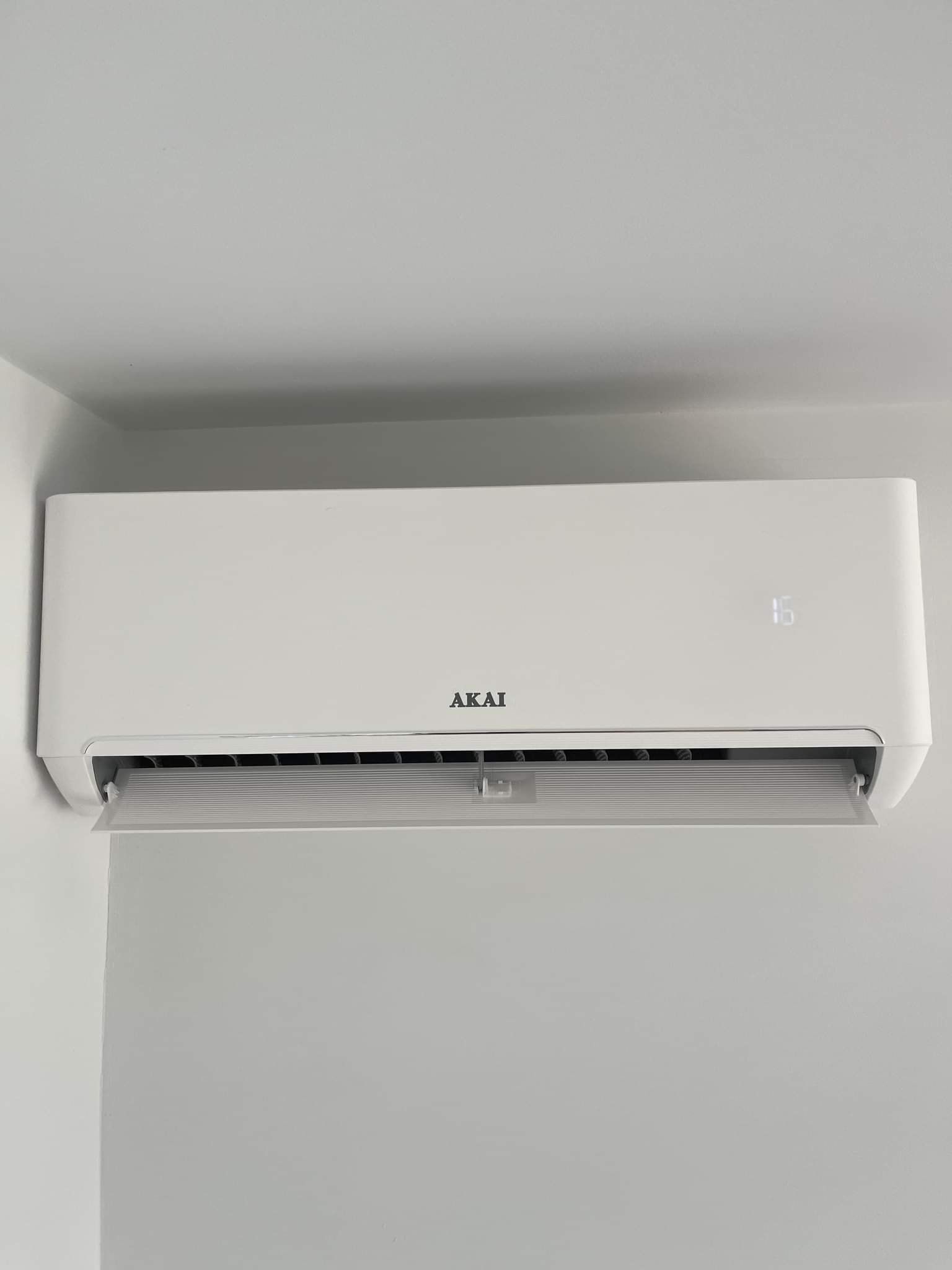 A White Air Conditioner Is Hanging from The Ceiling in A Room — Entire Trades in Maitland, NSW