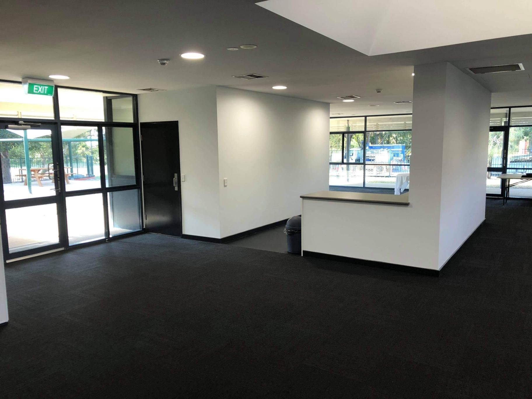 A Large Empty Room with A Lot of Windows and A Black Carpet — Entire Trades in Maitland, NSW