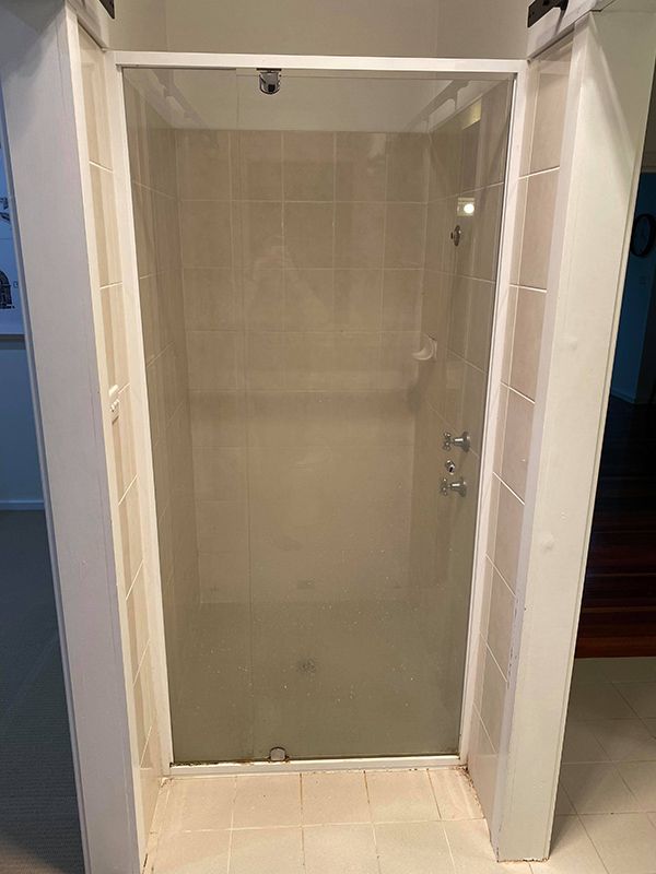 Glass Door Shower And Toilet In Bathroom — Entire Trades in Cessnock, NSW