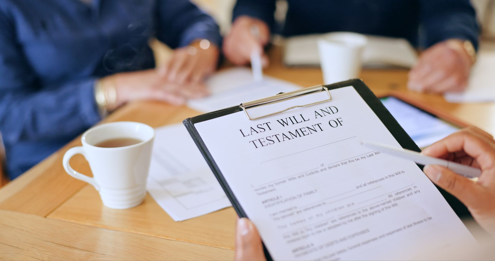 A wills lawyer reviewing estate planning documents with a couple at his office. A wills lawyer reviewing estate planning documents with a couple at his office.
