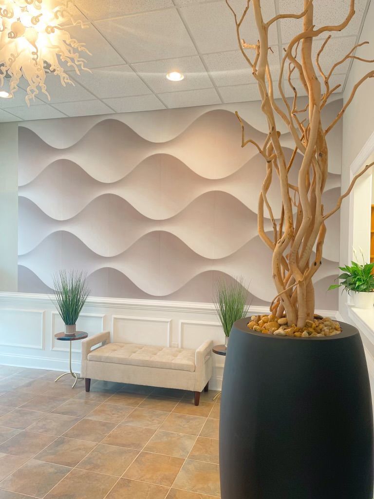 A waiting room with a couch and a potted plant