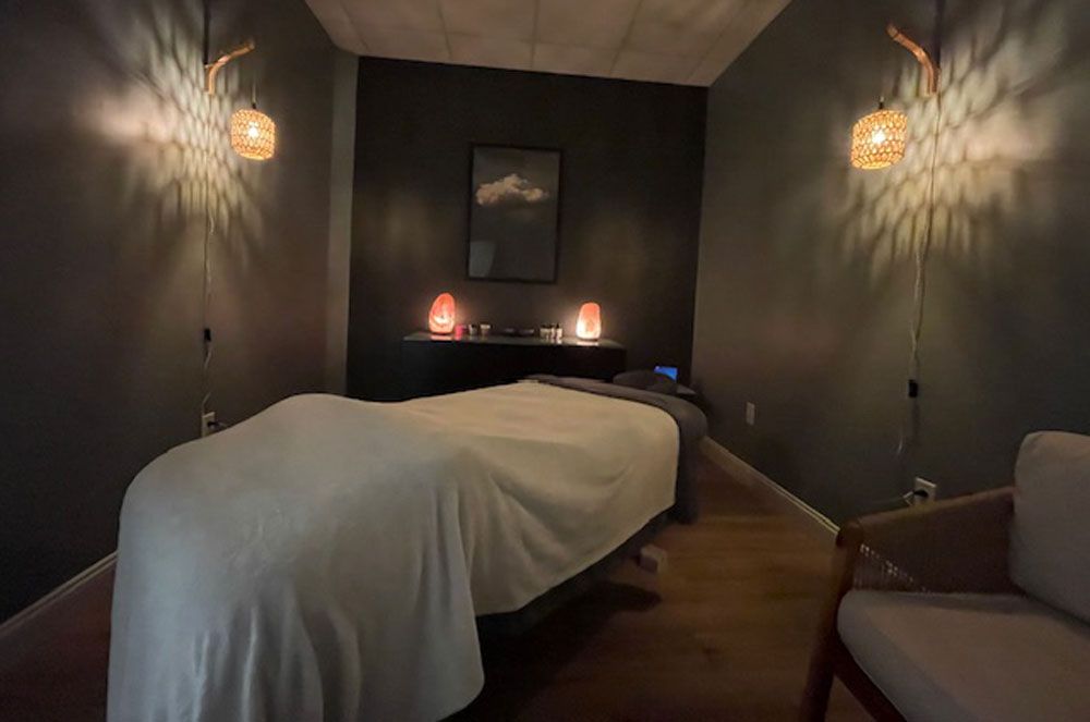 There is a massage table in the middle of the room.