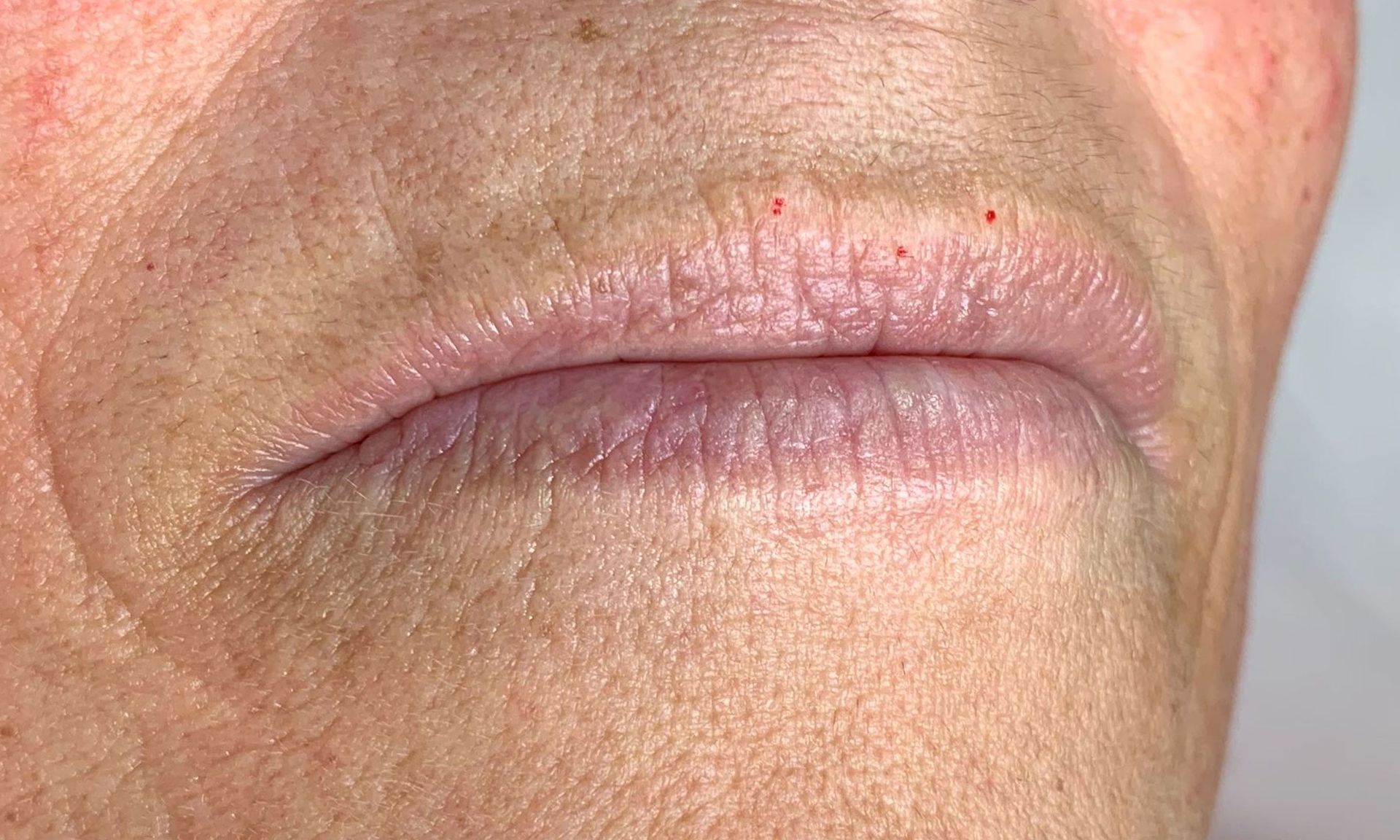 A close up of an elderly woman 's lips with wrinkles.