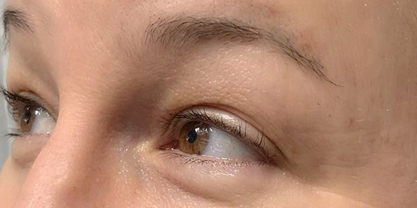 A close up of a woman 's eye and eyebrows.