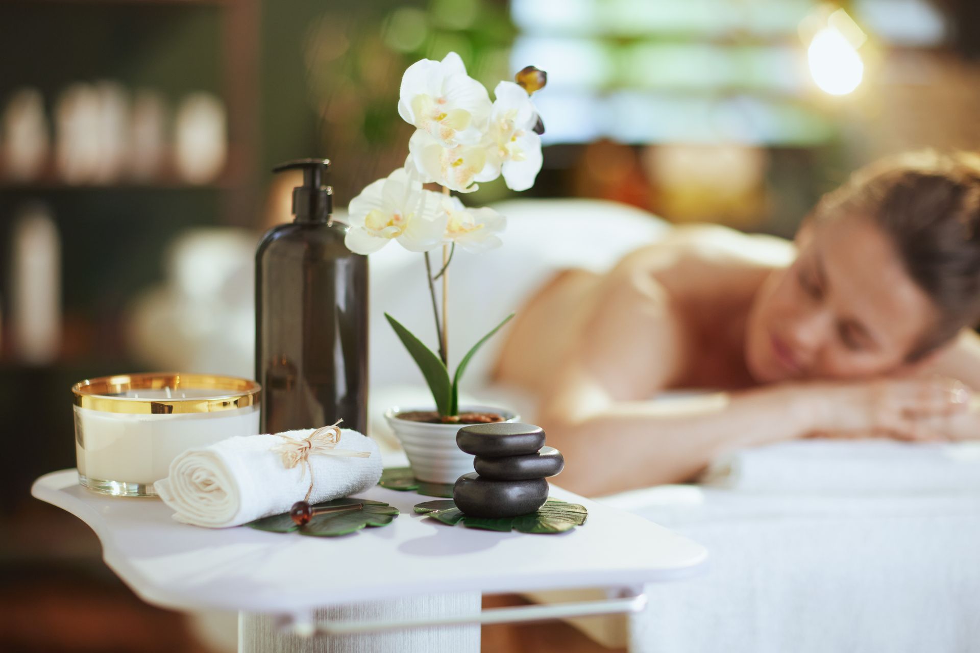 A woman is laying on a massage table in a spa.