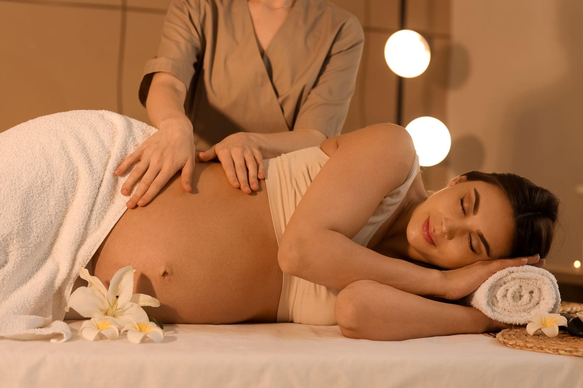 A pregnant woman is getting a massage at a spa.