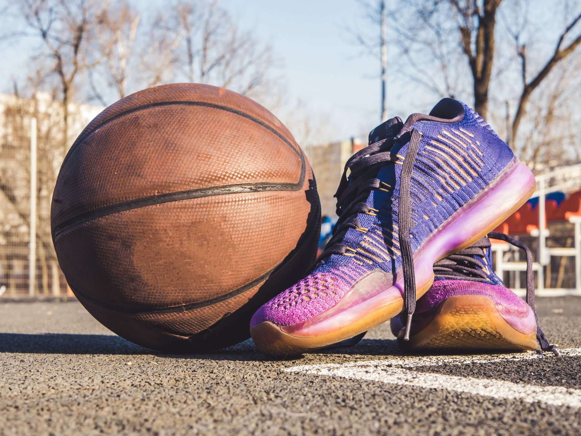 Worn basketball and shoes on a street ball court
