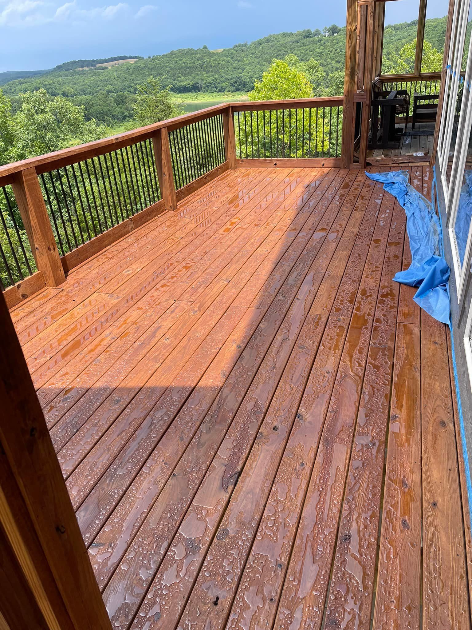 A wooden deck with a view of a forest and mountains.