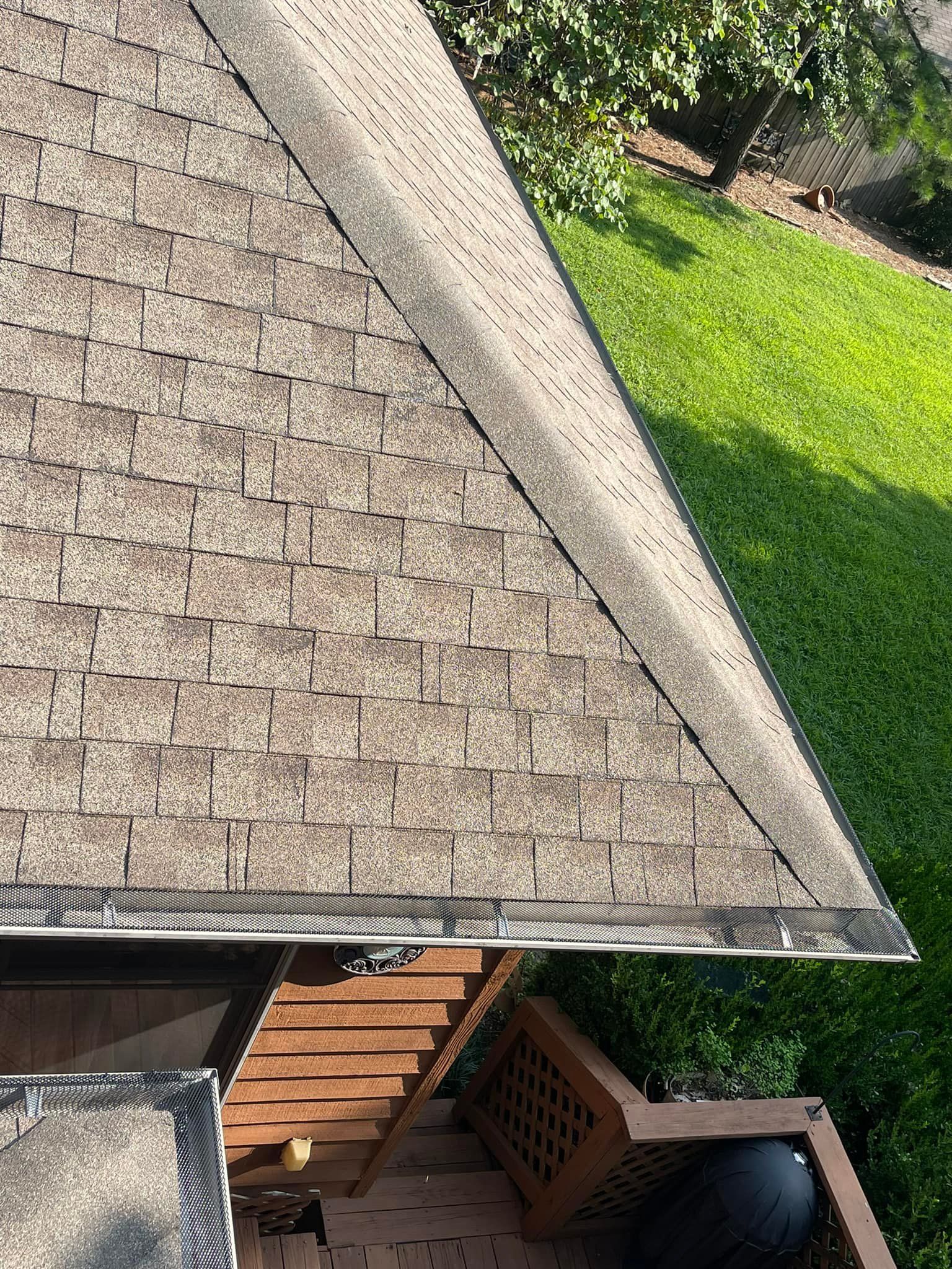 A close up of a roof with a deck in the background.