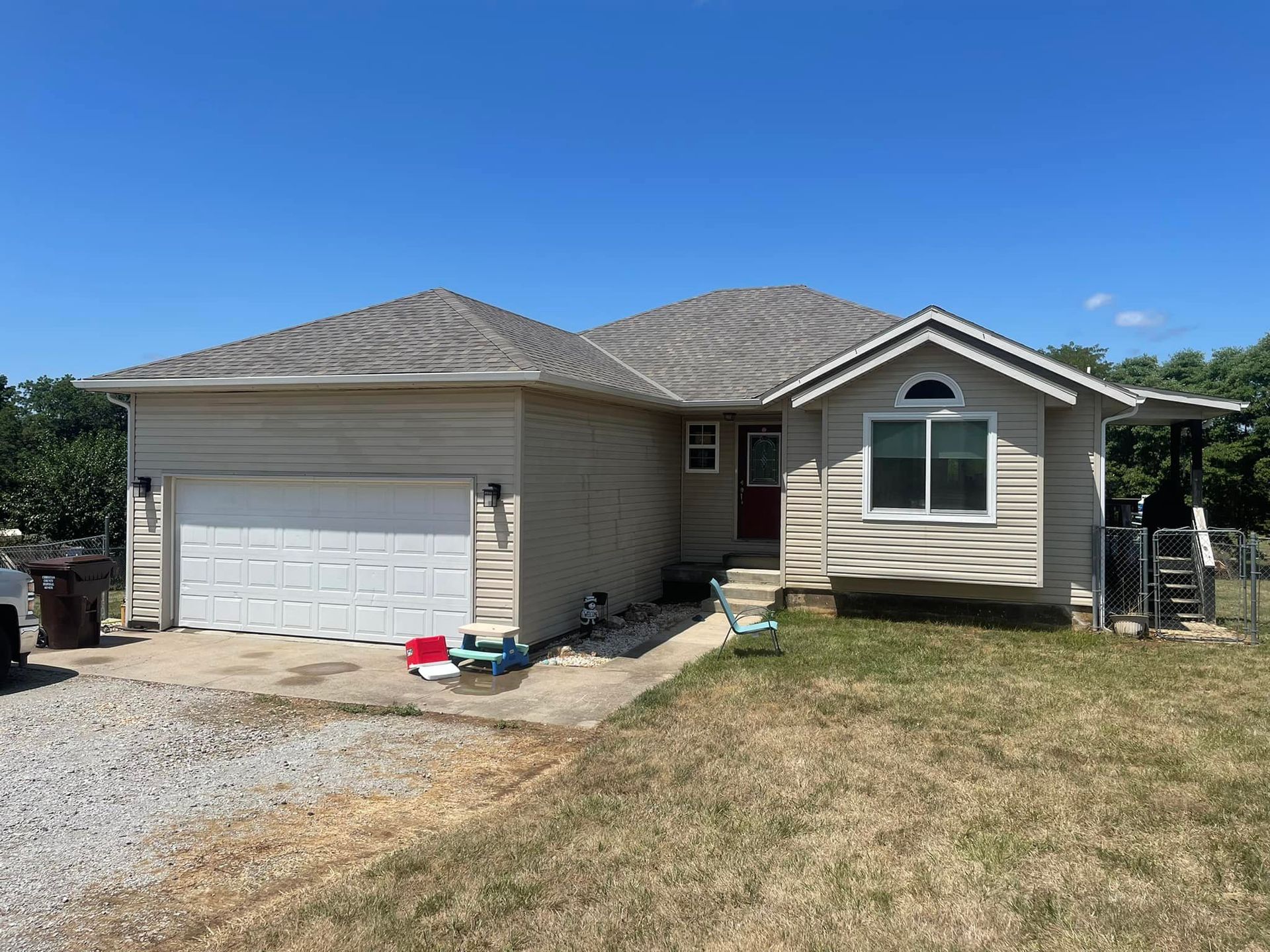 A small house with a garage and a car parked in front of it.