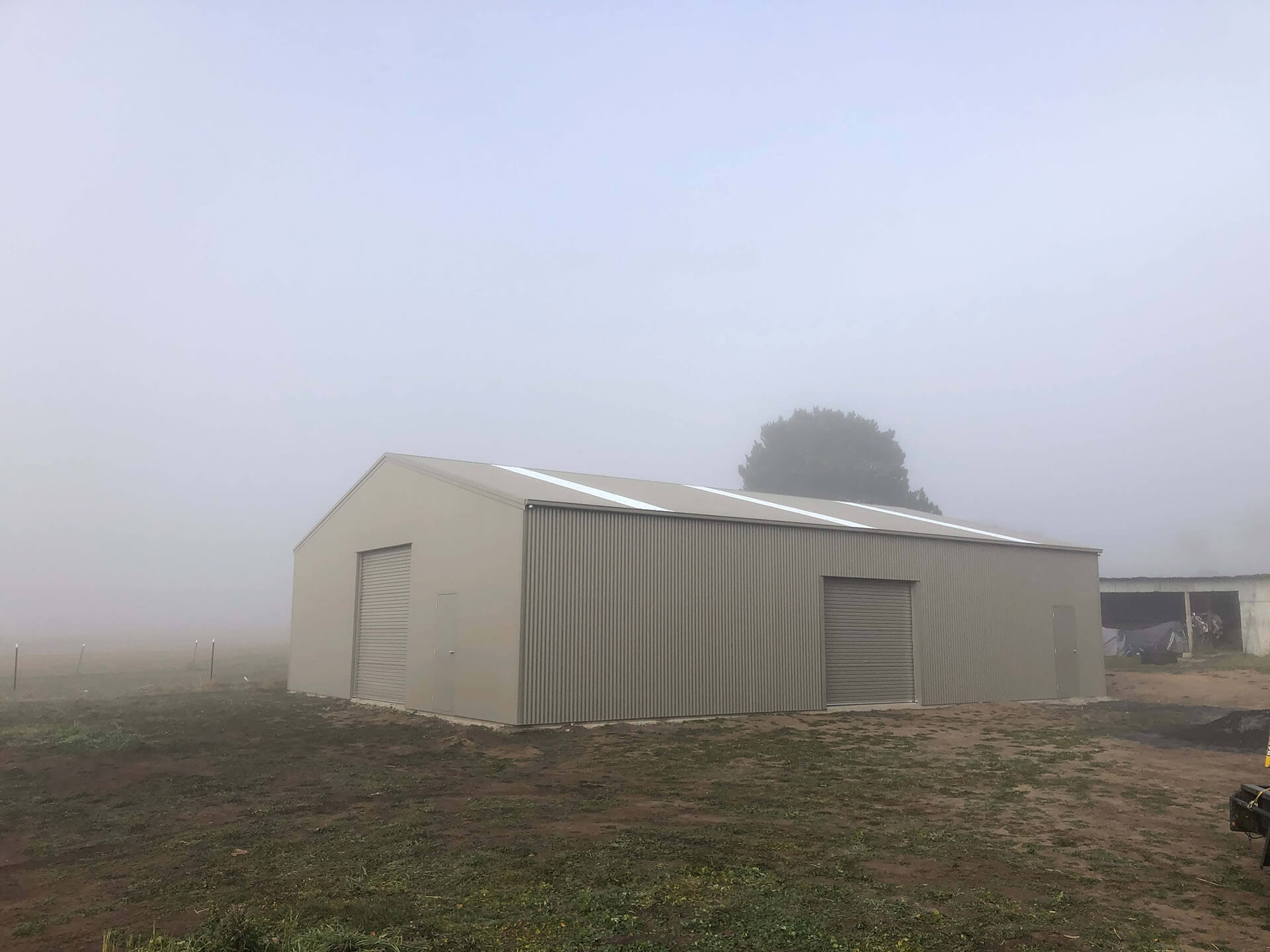 Black 1 door American style barn shed in fog