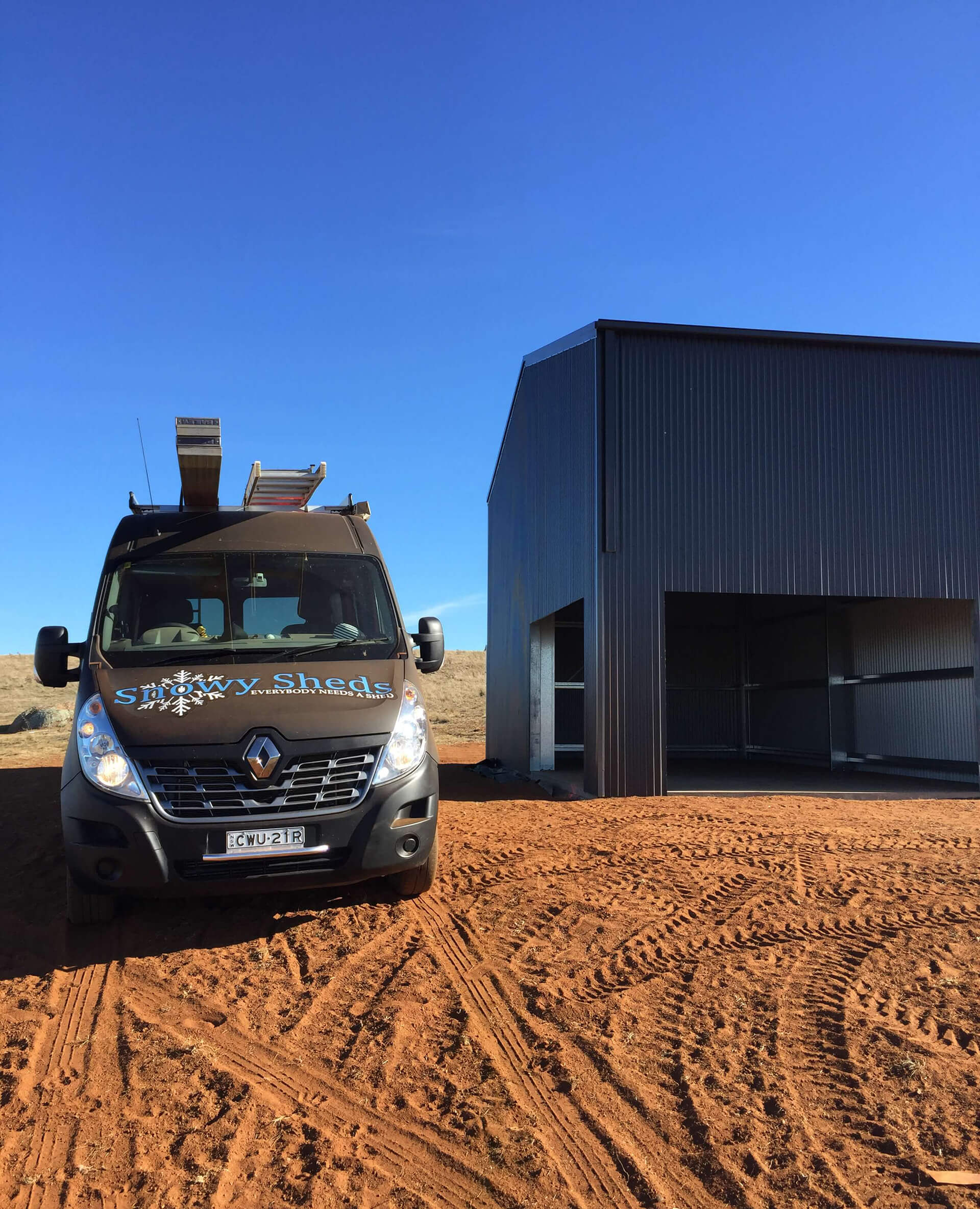 Industrial Steel Shed black with van in front - Snowy Sheds