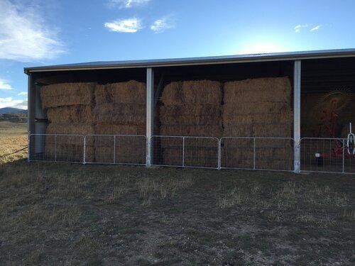 Large open farm shed with hay bales and farm equipment - Snowy Sheds