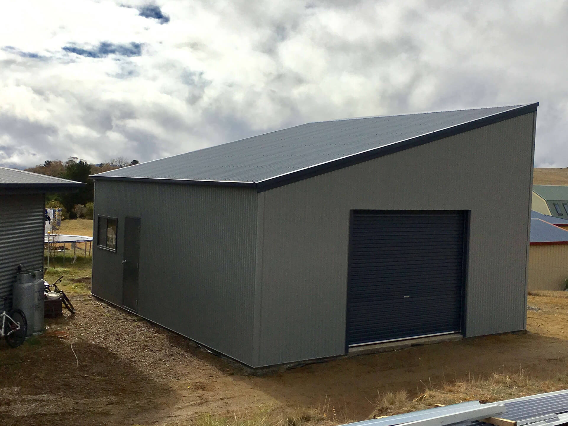 white shed with black roof  - Snowy Sheds