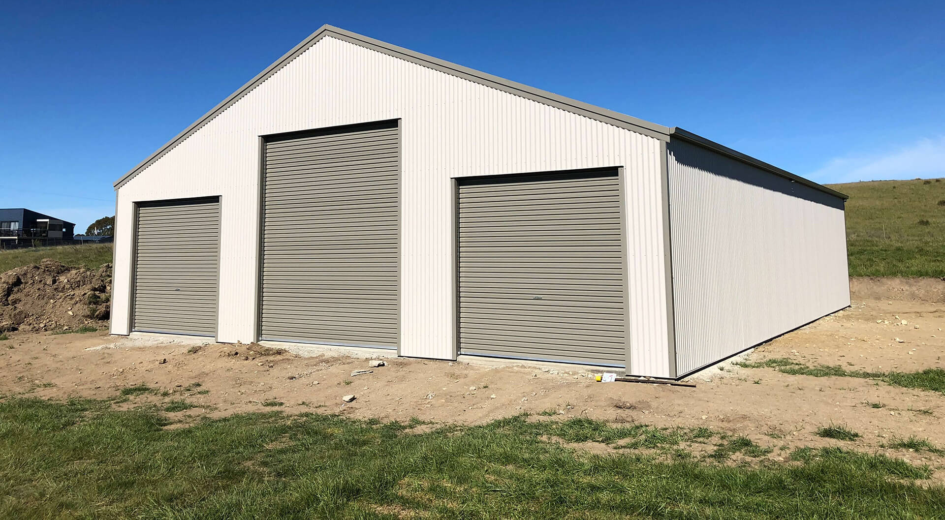 White industrial shed with three doors