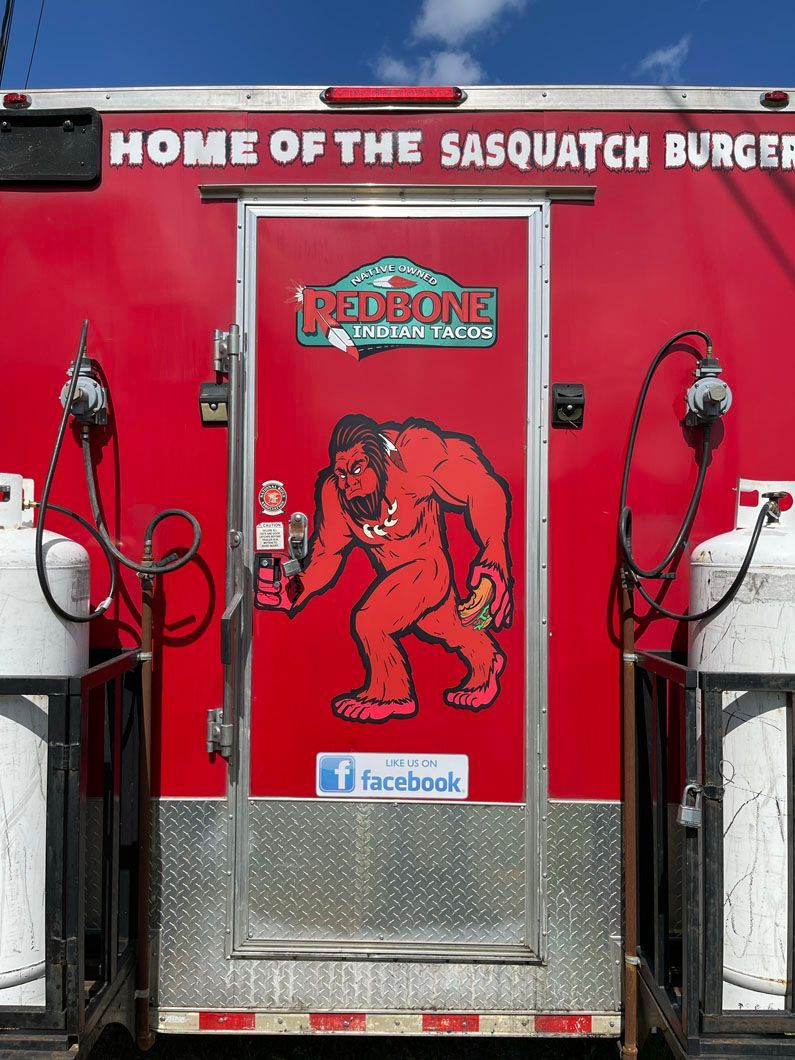 A red truck that says home of the sasquatch burger