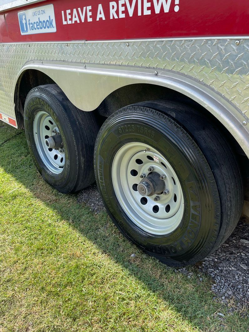 A trailer with a sign that says `` leave a review '' is parked in the grass.