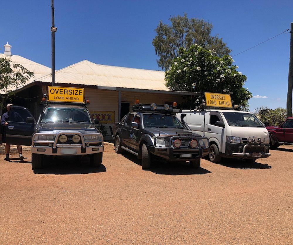 Three Vehicles Parked Outside a Building — Col Adamson Transport Services in Rockhampton, QLD