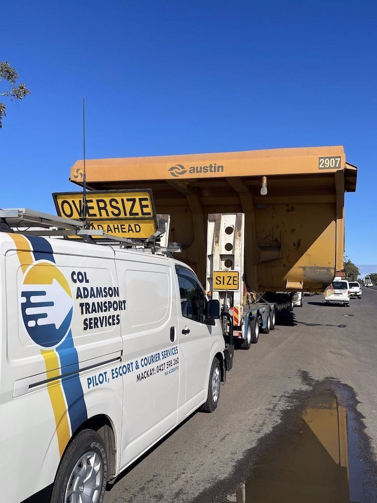 Oversized Mining Truck Being Transported on a Low Loader Trailer — Col Adamson Transport Services in Emerald, QLD