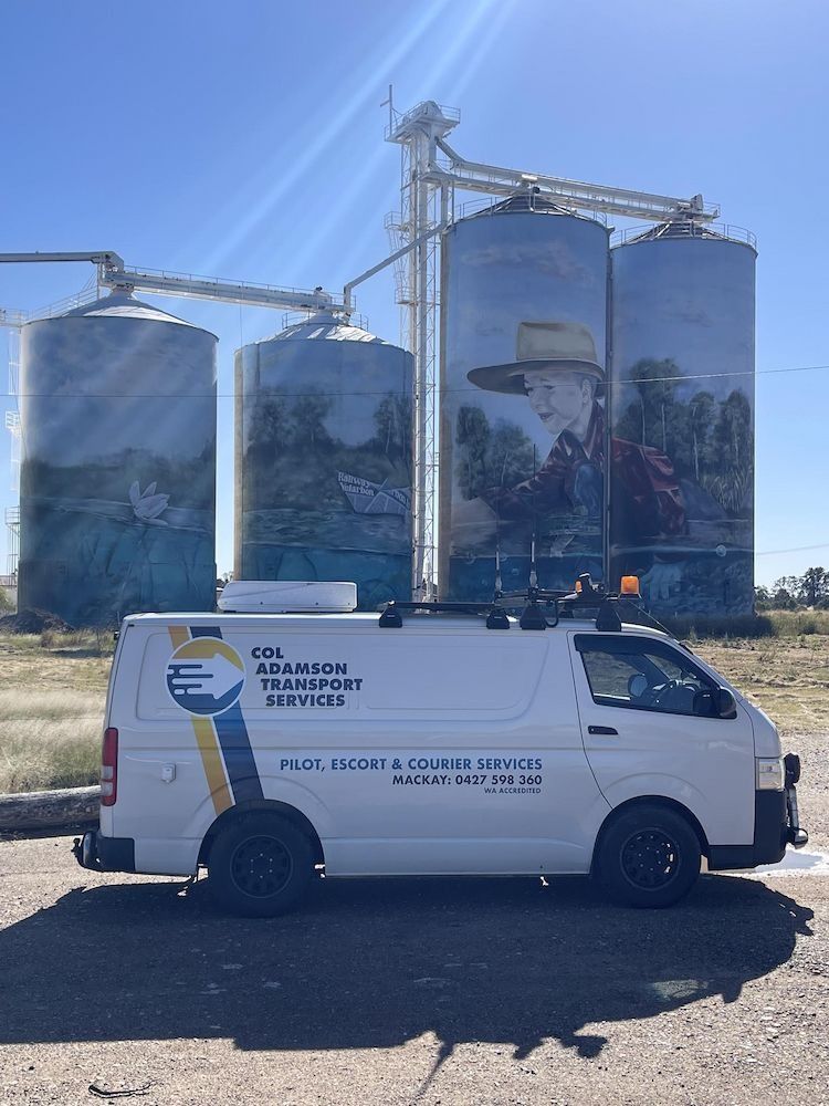 White Service Van in Front of Grain Silos With Painted Murals — Col Adamson Transport Services in Moranbah, QLD
