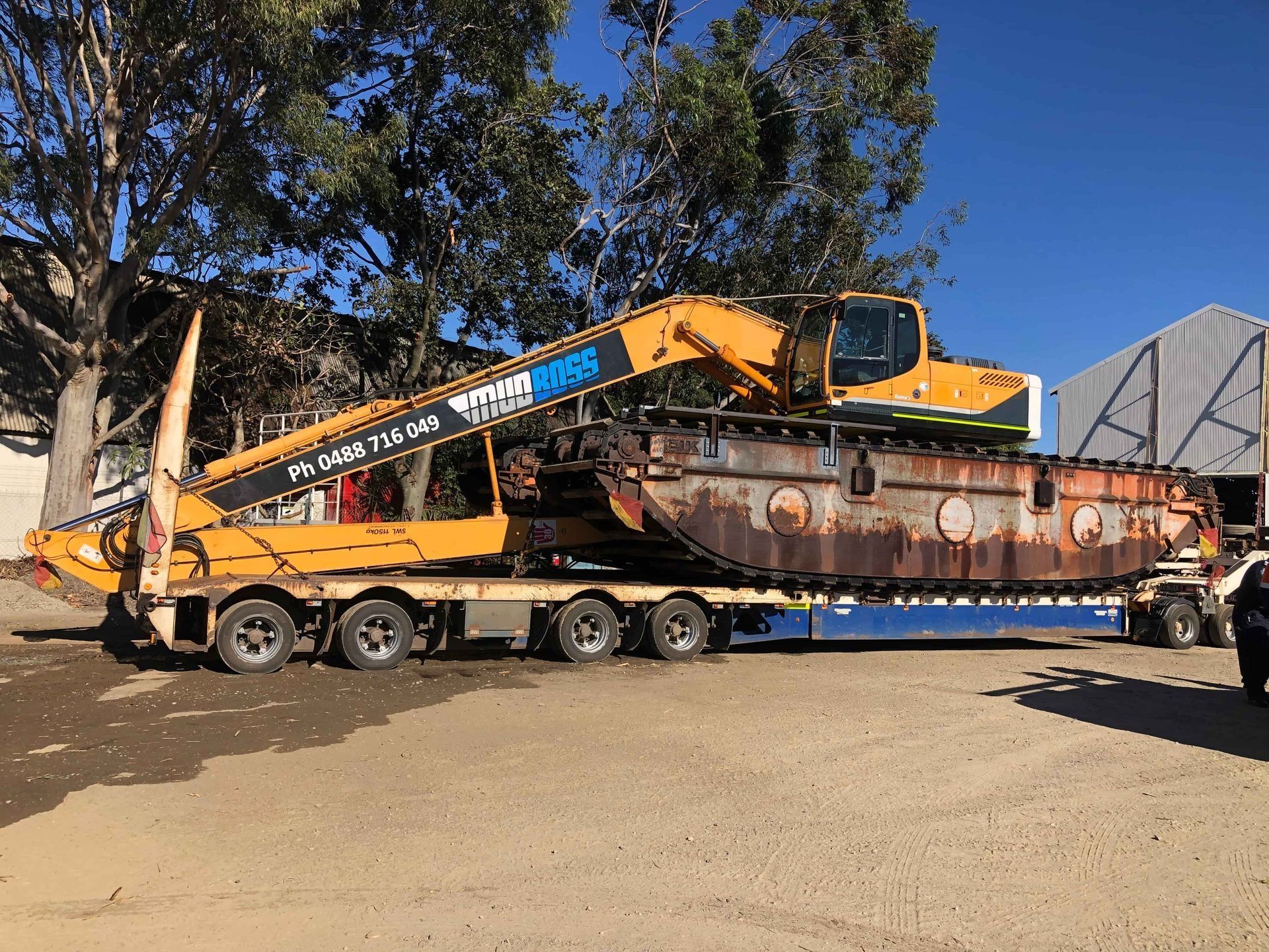 Yellow Excavator on Rusty, Pontoon-like Base — Col Adamson Transport Services in Farleigh, QLD
